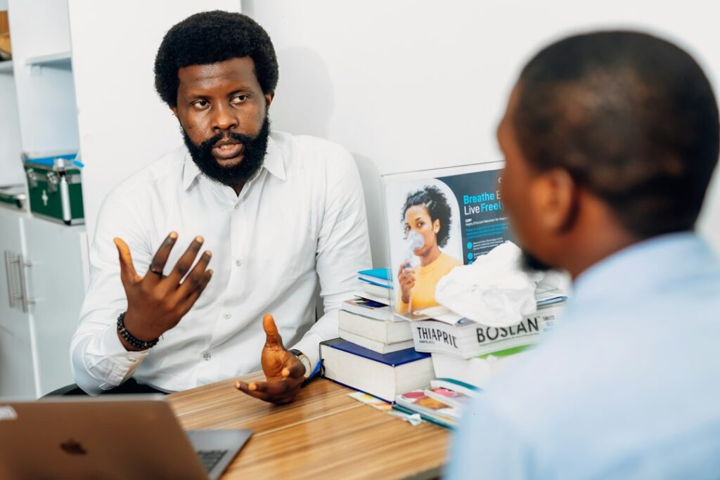 A Black doctor speaking with a patient during a medical consultation